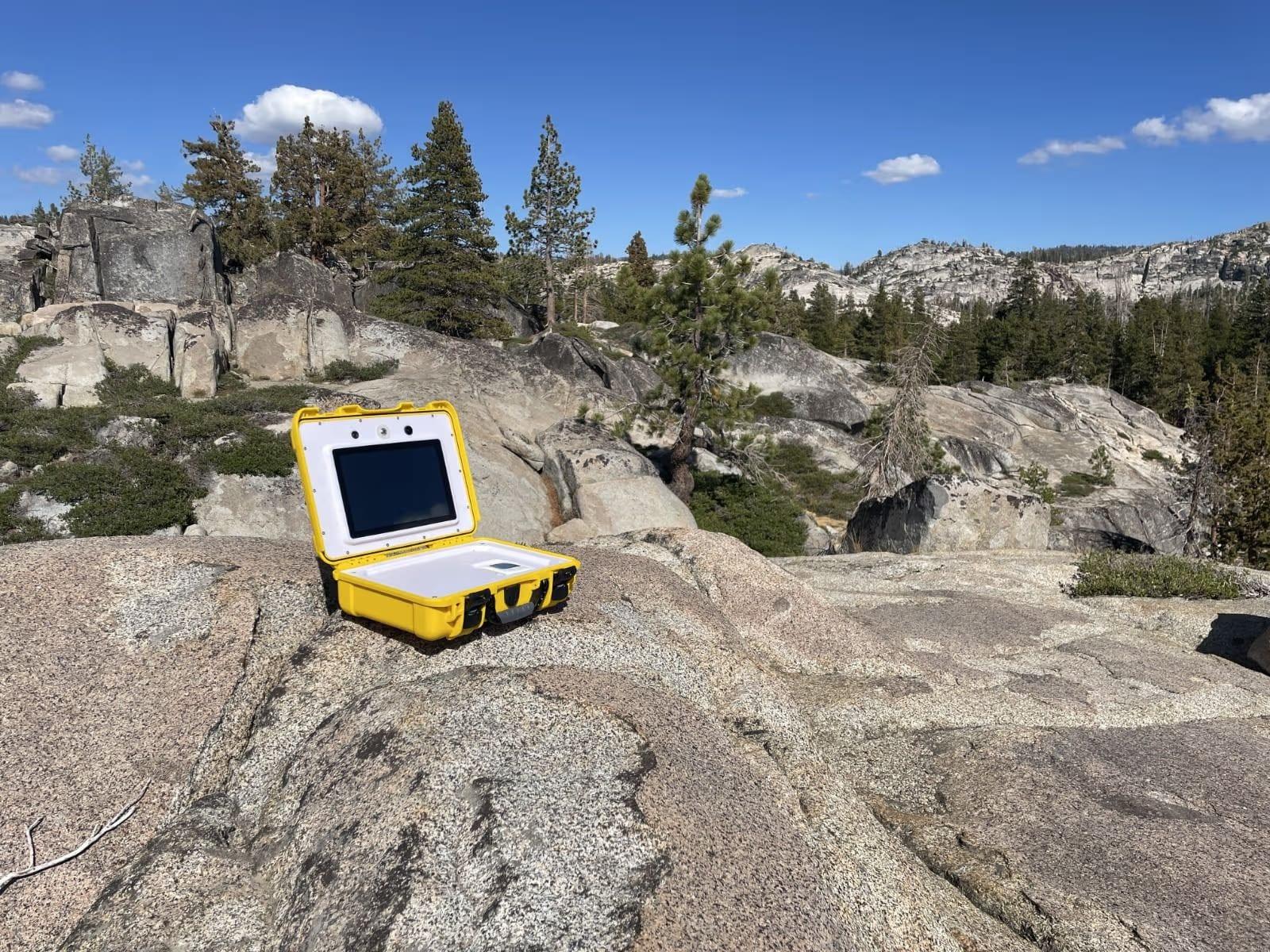A Cosight device open on a granite outcrop in the high backcountry, far from any road
